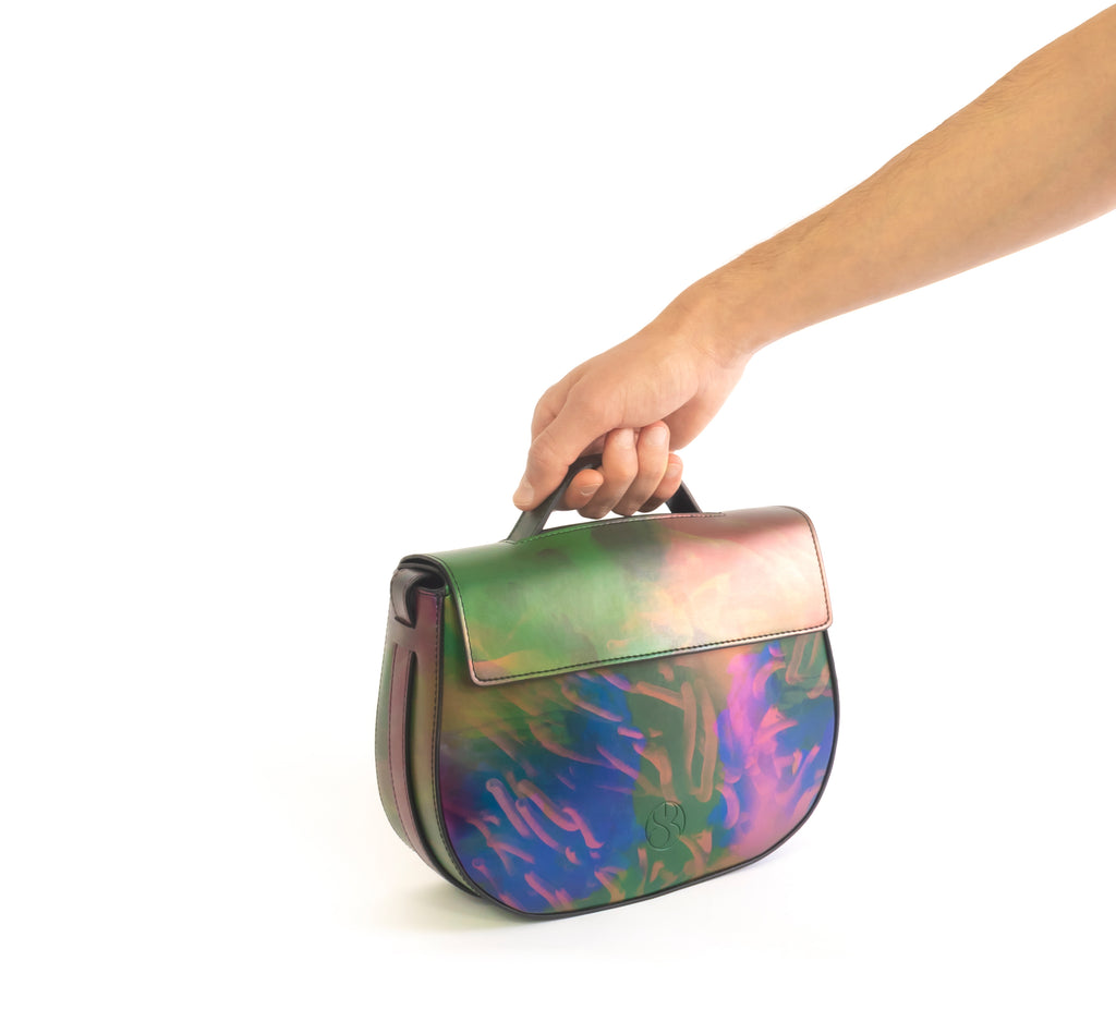 Printed iridescent vegan leather crossbody bag by Sydney Brown. Timeless, classic and modern. Hand view