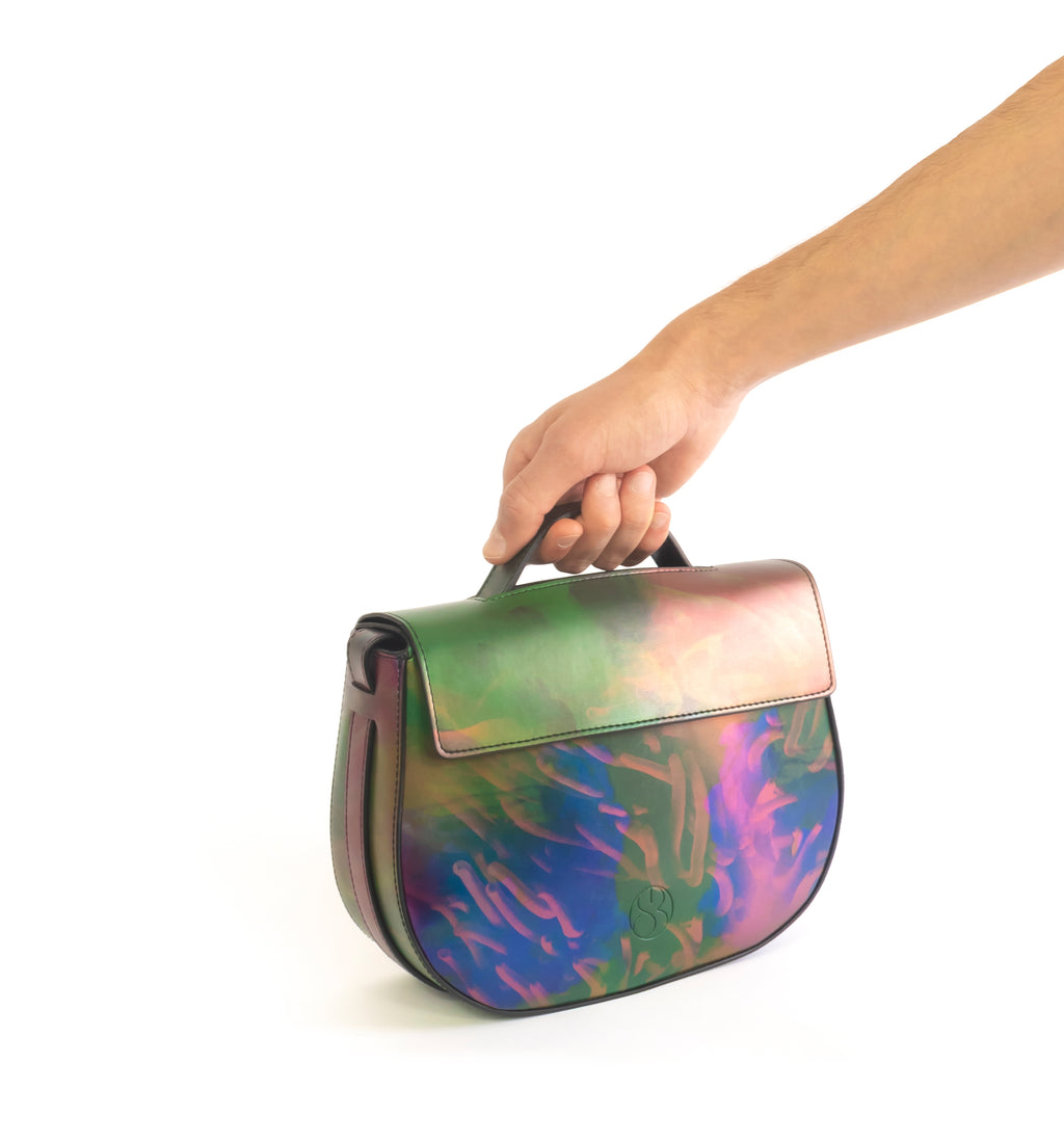 Printed iridescent vegan leather crossbody bag by Sydney Brown. Timeless, classic and modern. Hand view