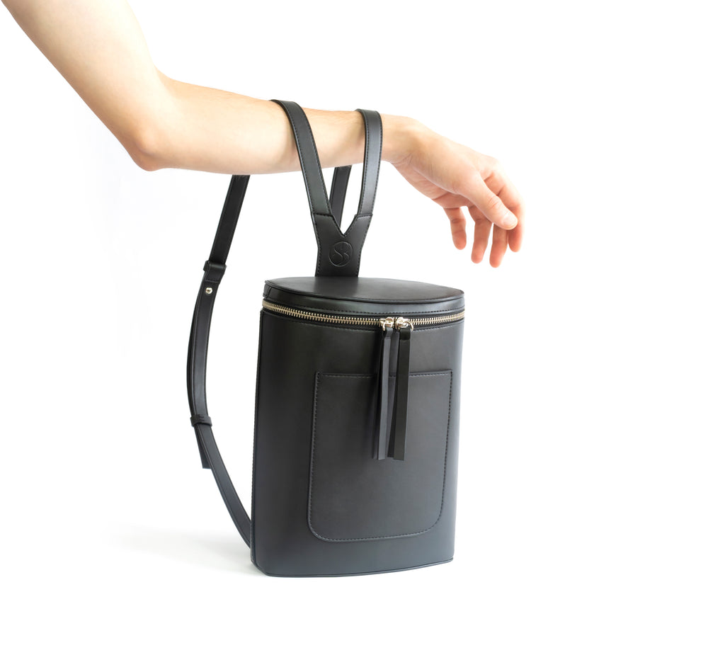 Black eco vegan leather bucket backpack by Sydney Brown. Timeless, classic and modern. Hand view