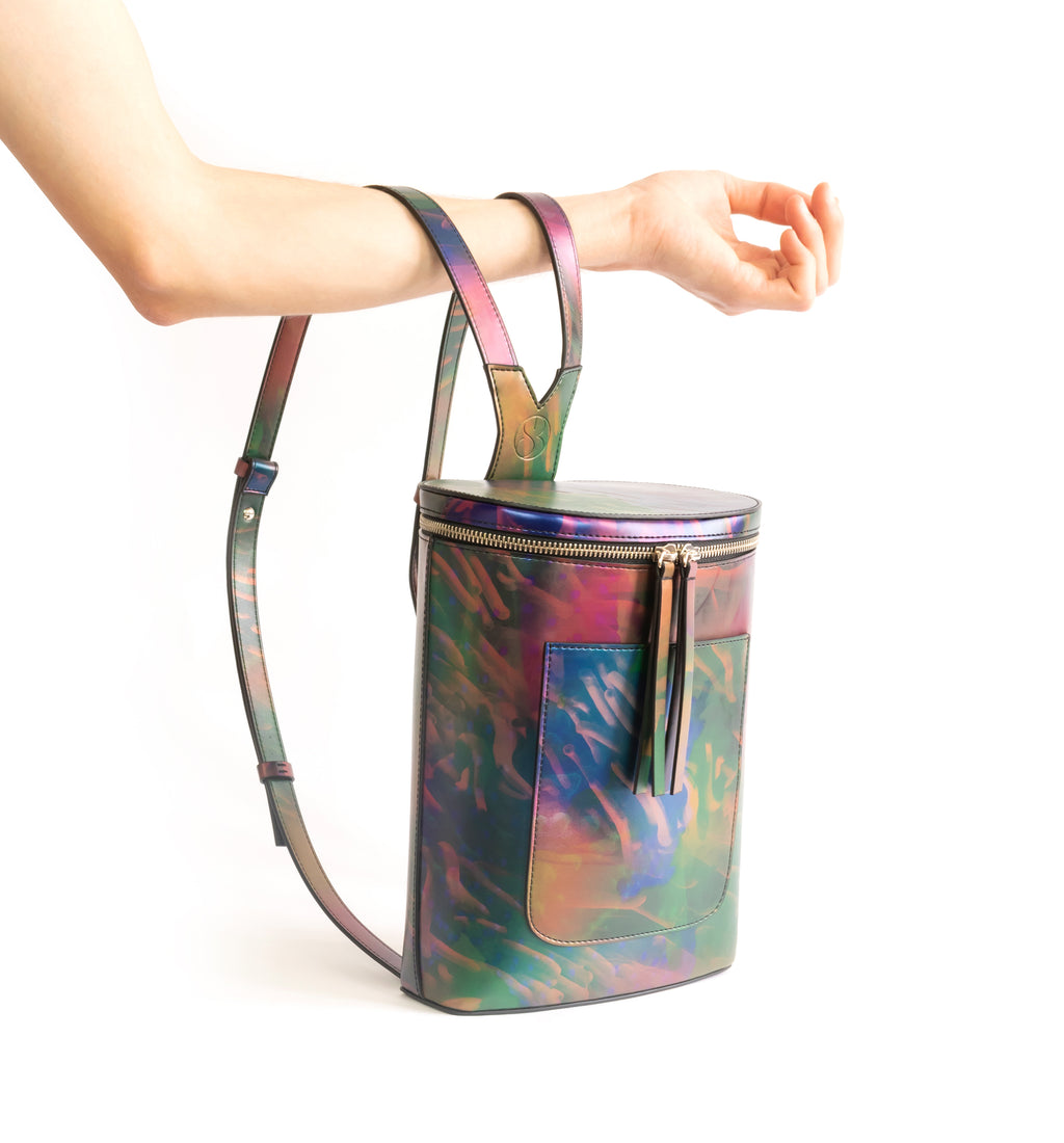 Printed iridescent vegan leather bucket backpack by Sydney Brown. Timeless, classic and modern. Hand View