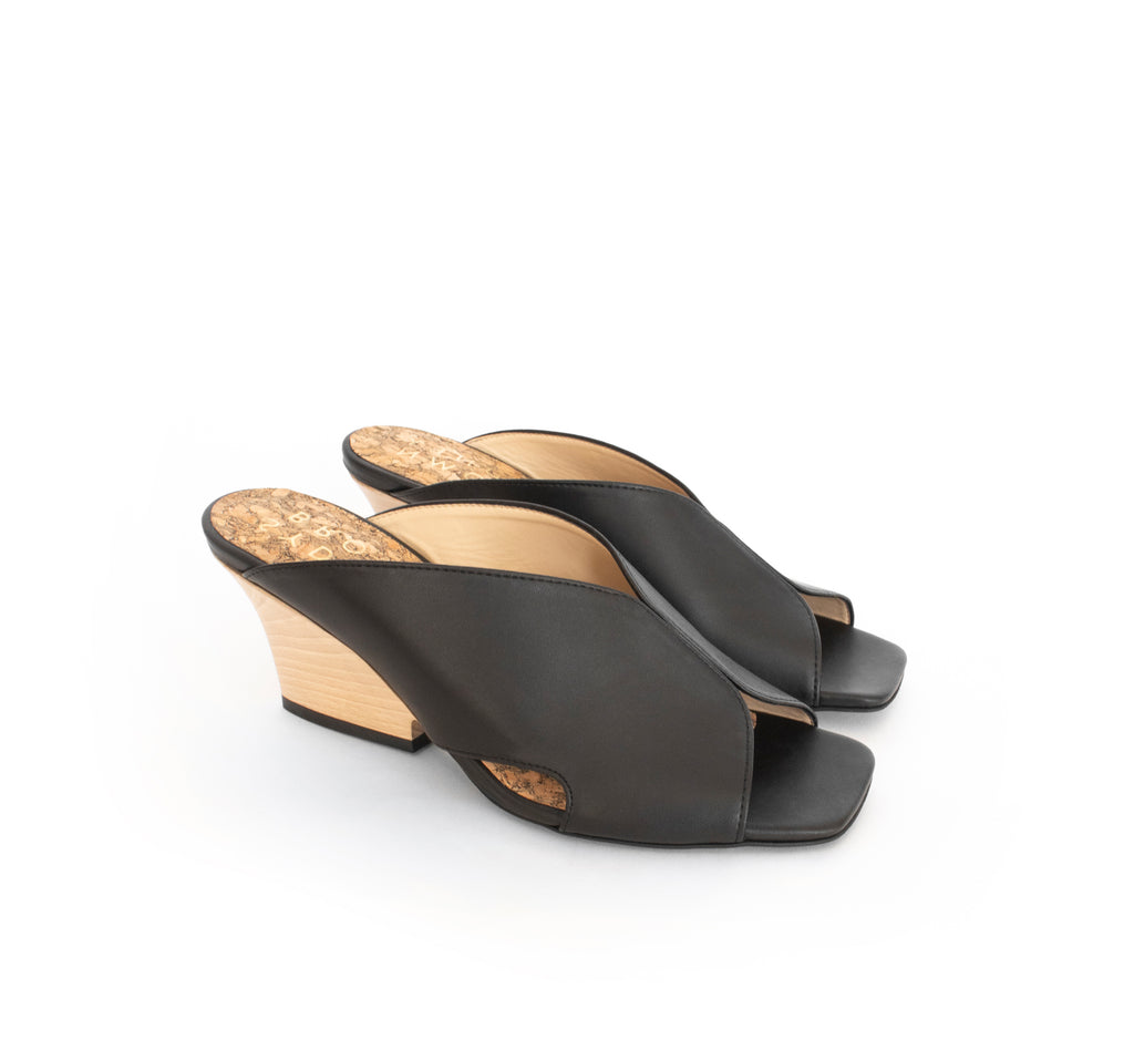 Black faux-leather mule slide with a curved design high heel in light brown wood.