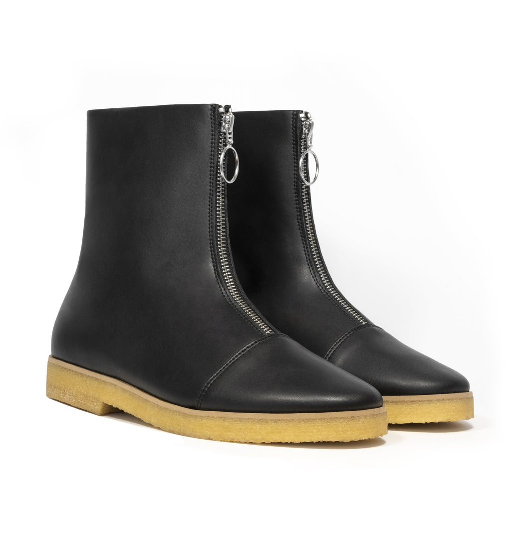 Black vegan leather boot with frontal zip, almond toe, natural rubber crepe sole.
