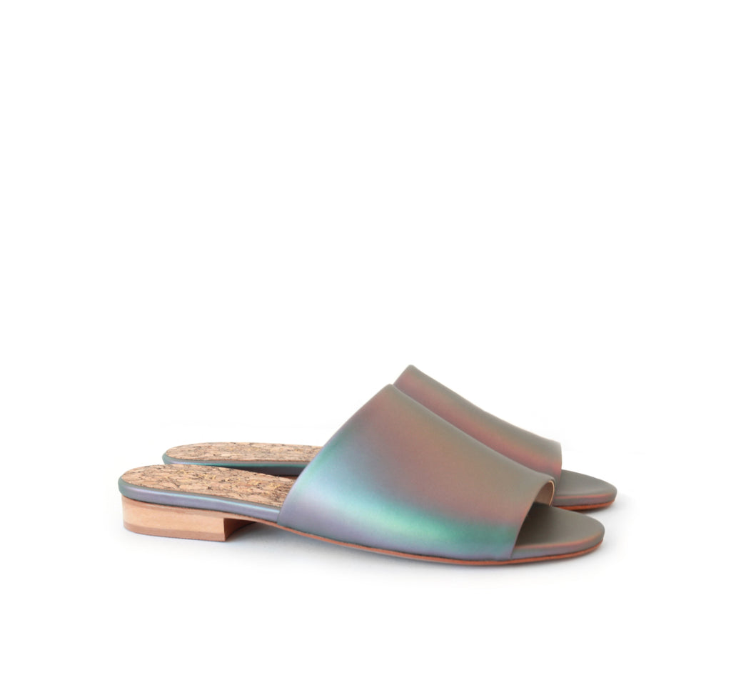 Flat slides in iridescent vegan leather, small wood heel.