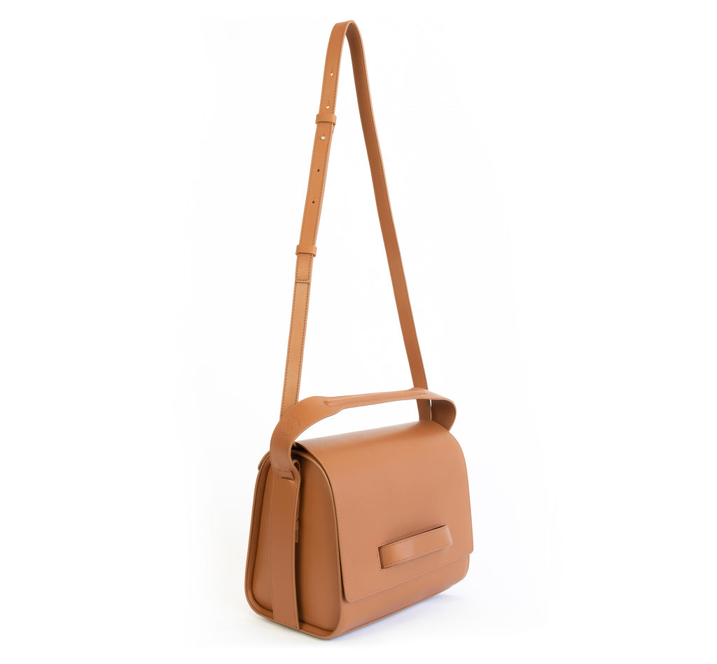 Brown eco vegan leather barrel shoulder bag by Sydney Brown. Timeless, classic and modern. Angle front view shoulder strap