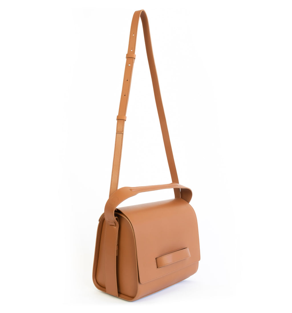 Brown eco vegan leather barrel shoulder bag by Sydney Brown. Timeless, classic and modern. Angle front view shoulder strap