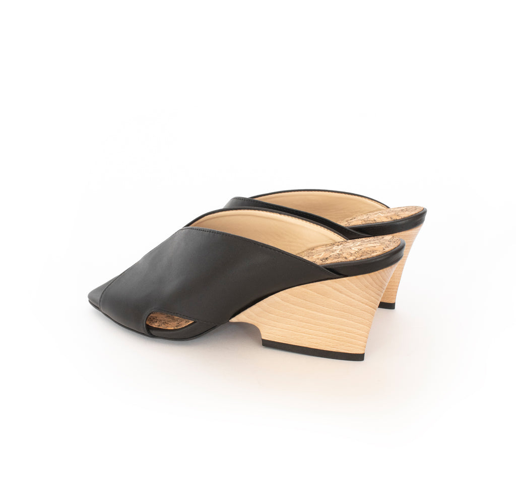 Black faux-leather mule slide with a curved design high heel in light brown wood.