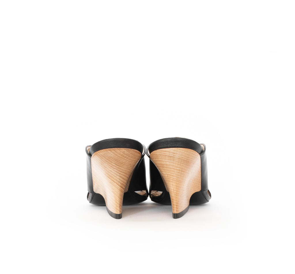 Black faux-leather mule slide with a curved design high heel in light brown wood.
