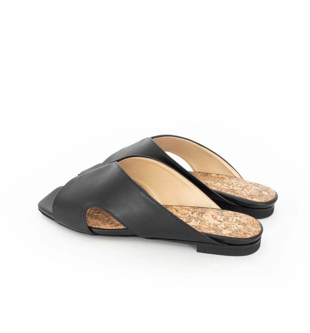 Black faux-leather slide with a black flat sole.