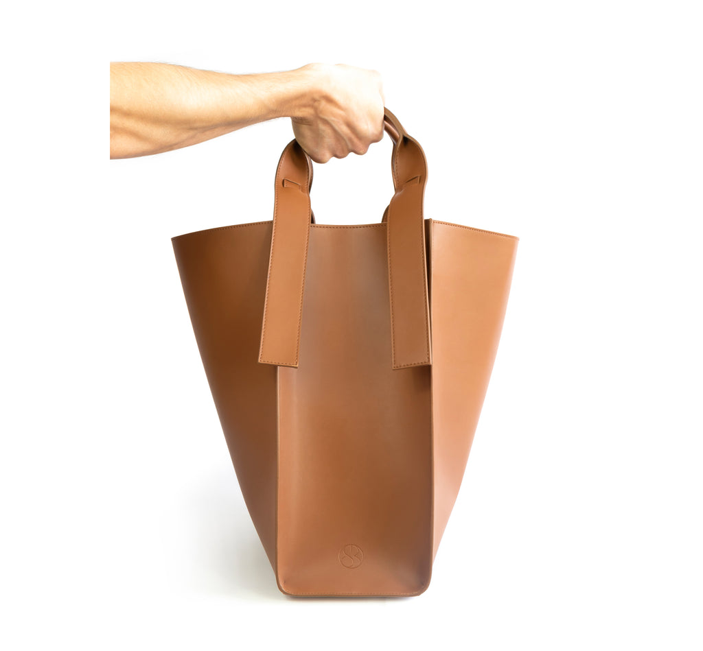 Brown eco vegan leather tote shoulder bag by Sydney Brown. Timeless, classic and modern. Hand view.