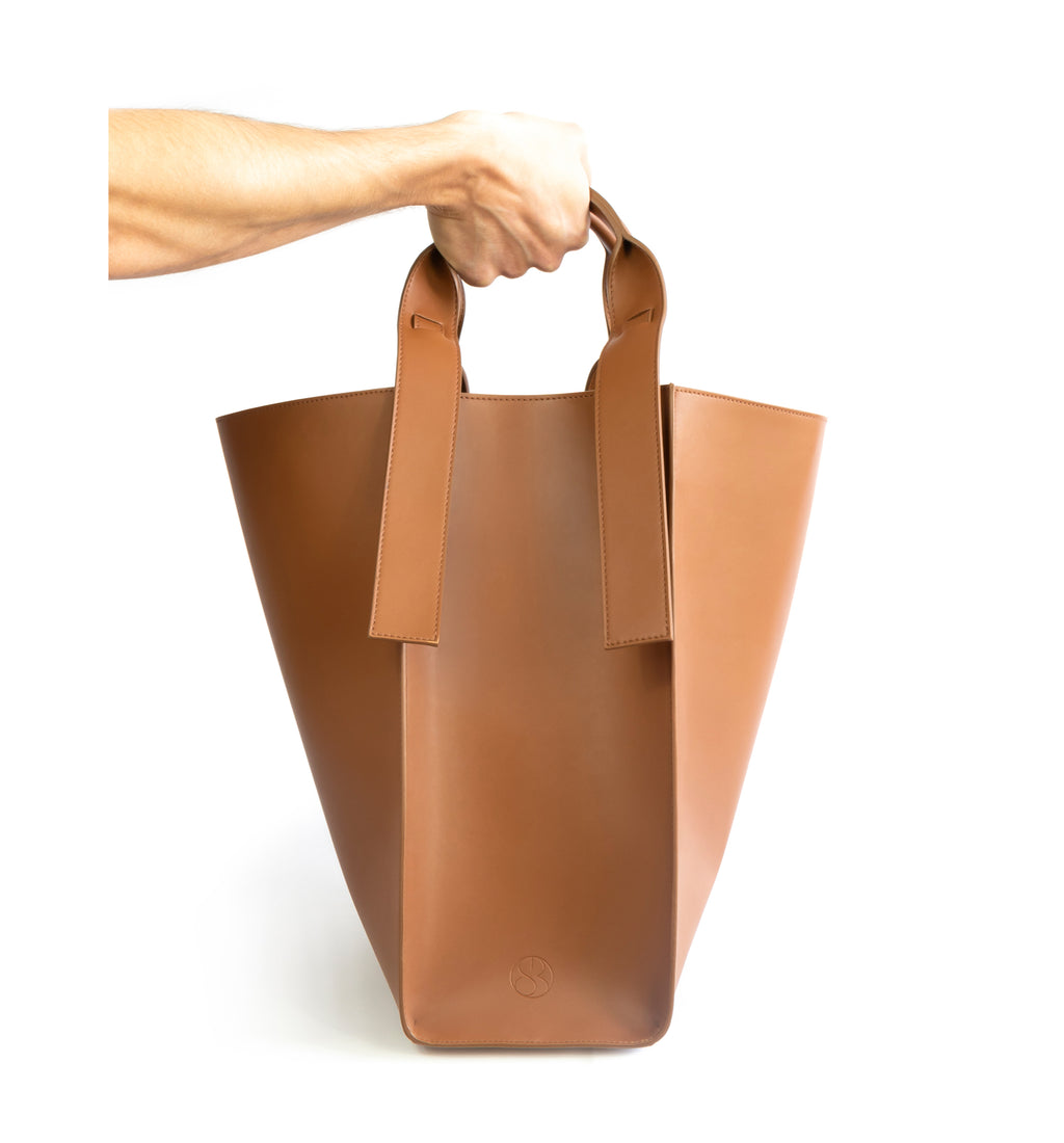 Brown eco vegan leather tote shoulder bag by Sydney Brown. Timeless, classic and modern. Hand view.